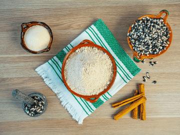 A flat-lay image showcasing natural wellness ingredients, including cinnamon sticks, seeds, and herbs on a wooden table, symbolizing holistic health and aromatherapy.