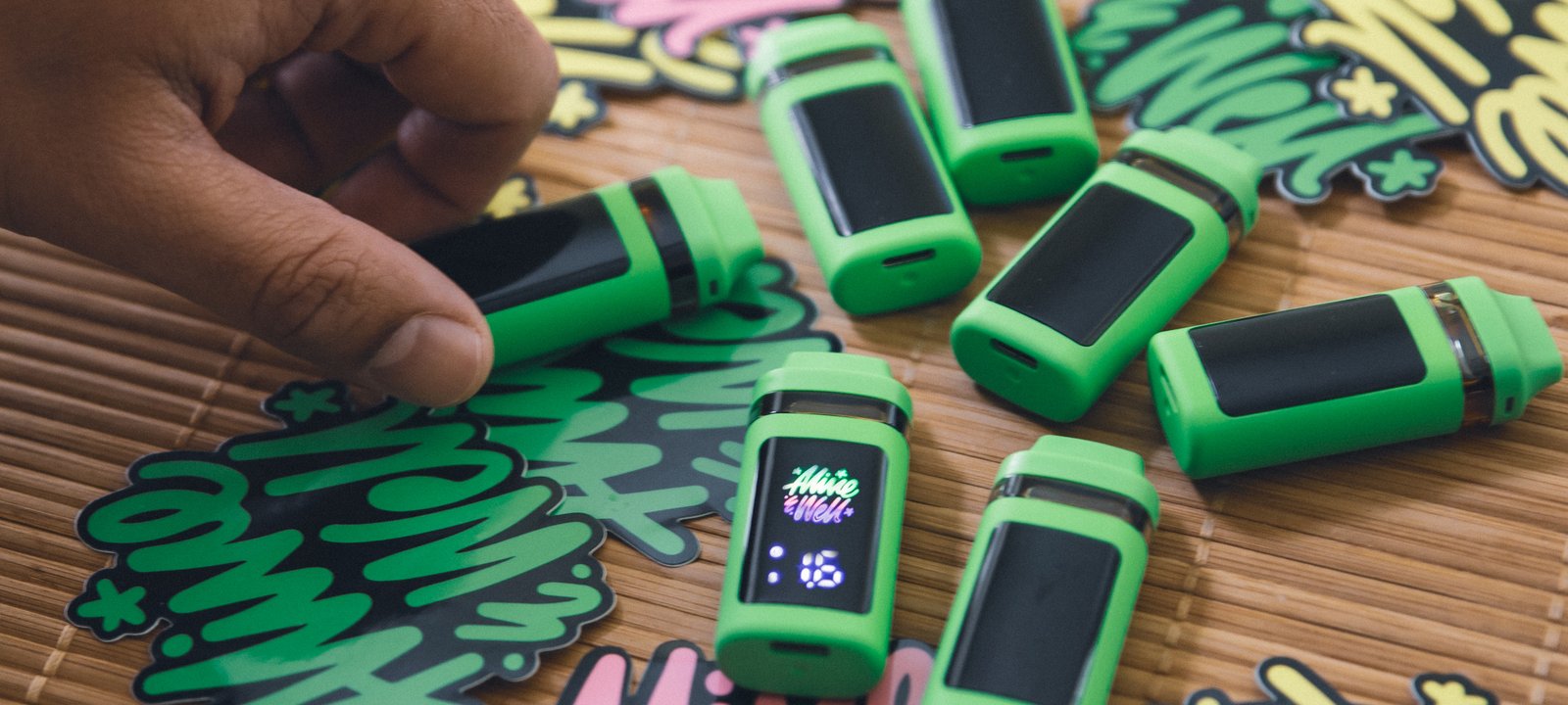 Alive & Well Digital Disposable devices arranged on bamboo with brand sticker artwork